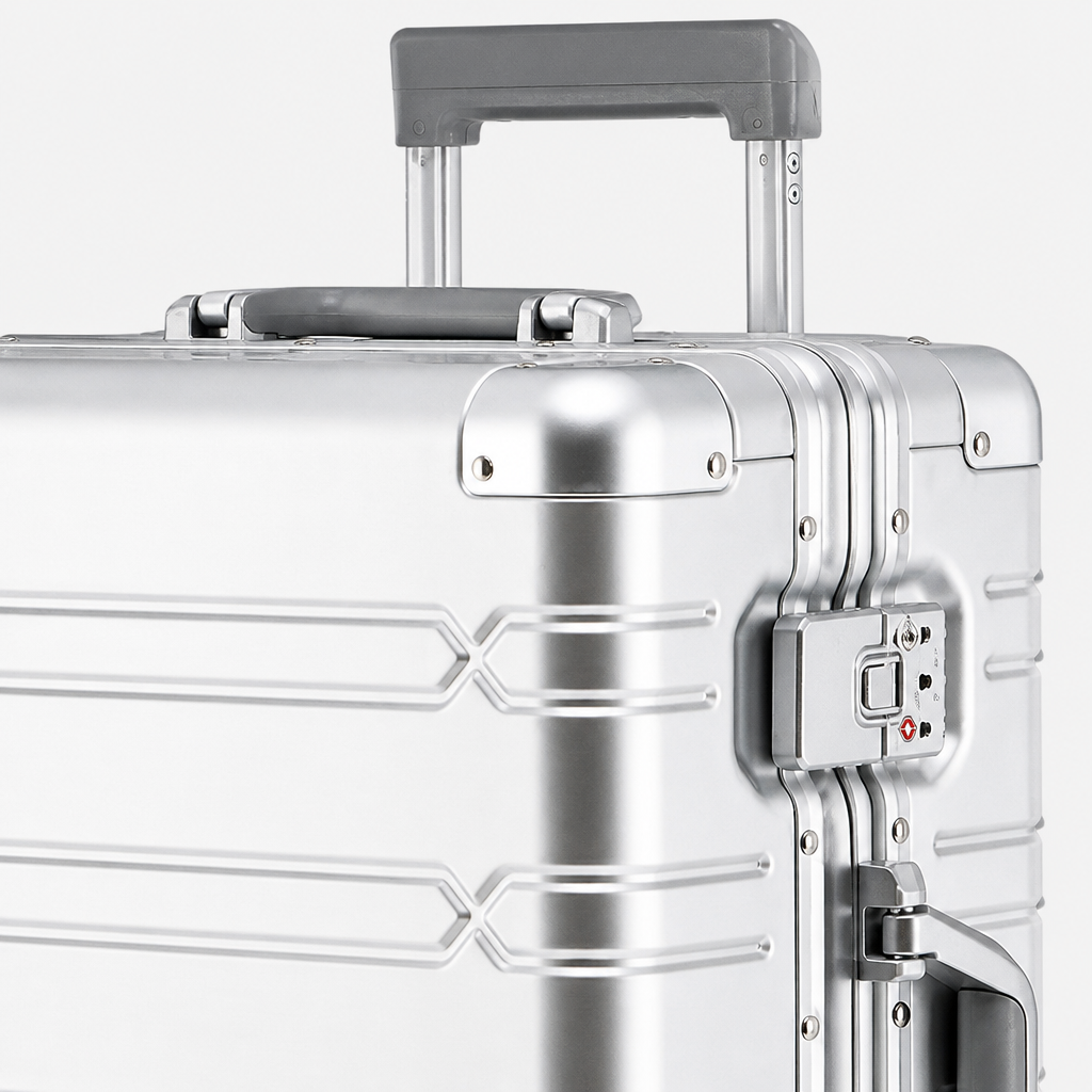 Valise cabine en aluminium argent, gros plan studio gris
